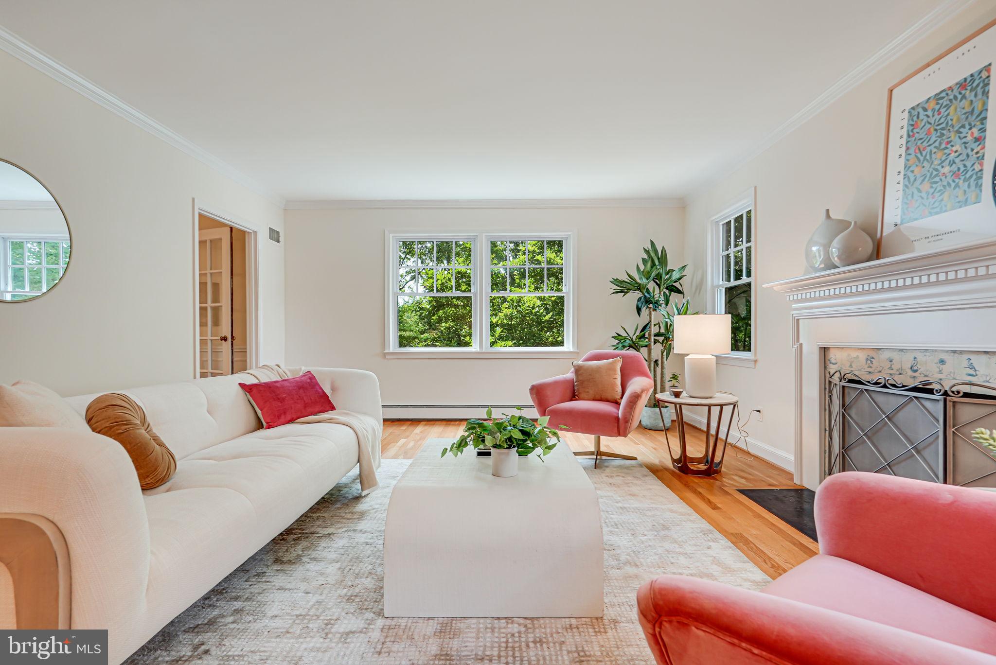 a living room with furniture fireplace and a large window