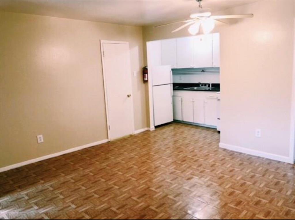 a view of a kitchen with wooden cabinet and a refrigerator