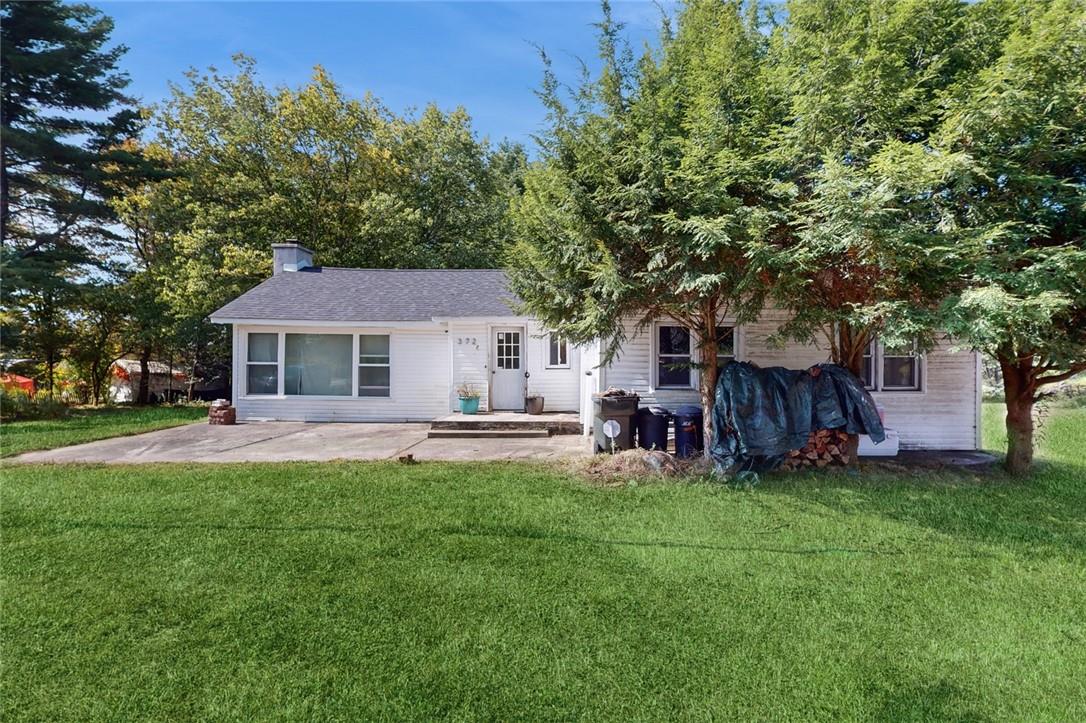 Rear view of property with a lawn