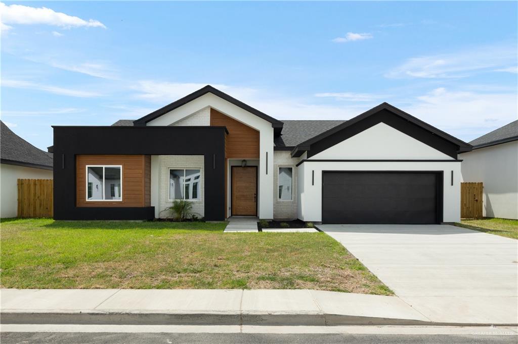 a front view of a house with yard and garage