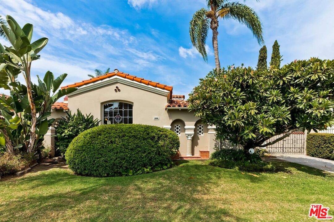 a view of a house with a yard and potted plants