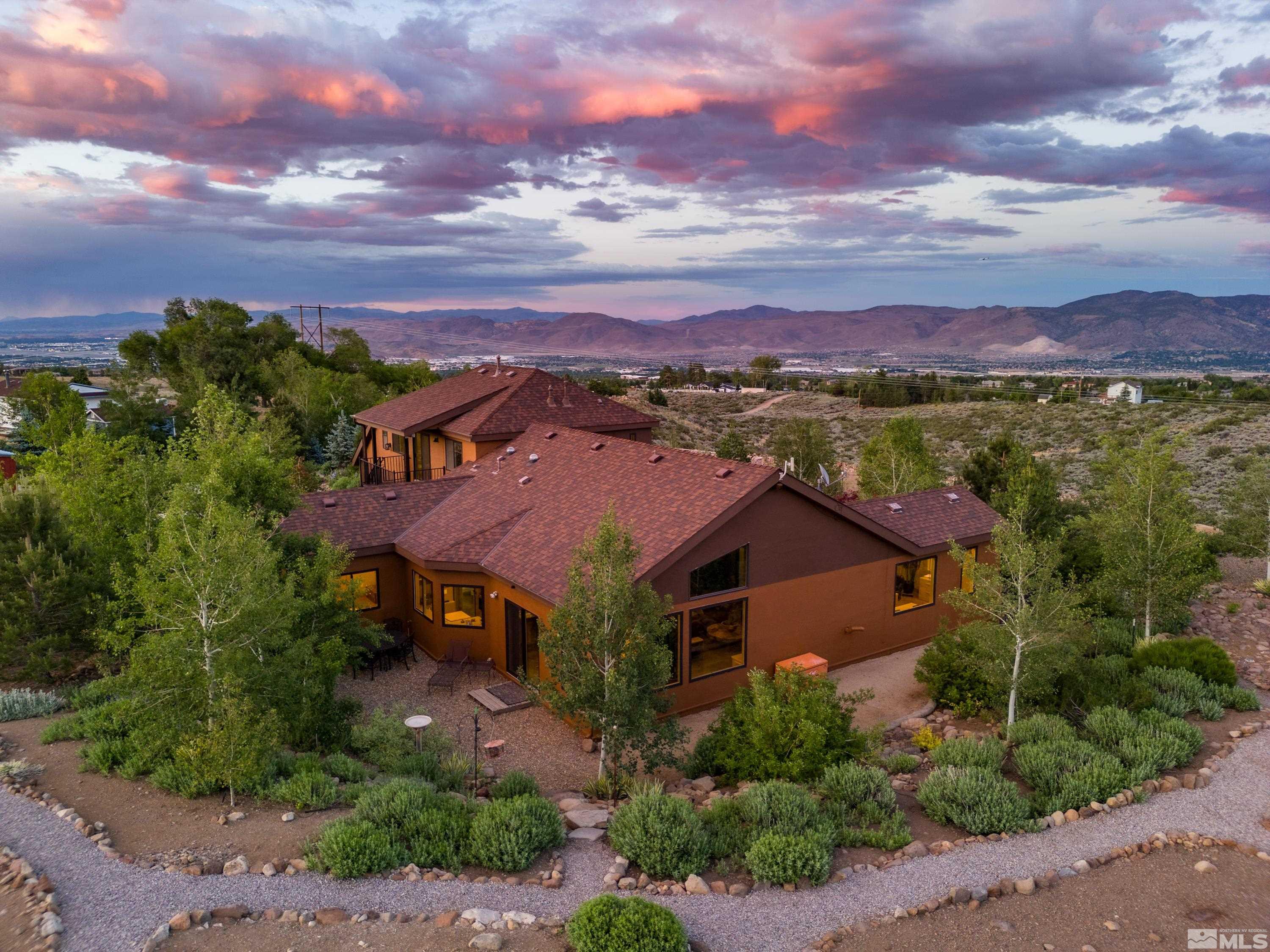 a aerial view of a house with a yard and mountain view