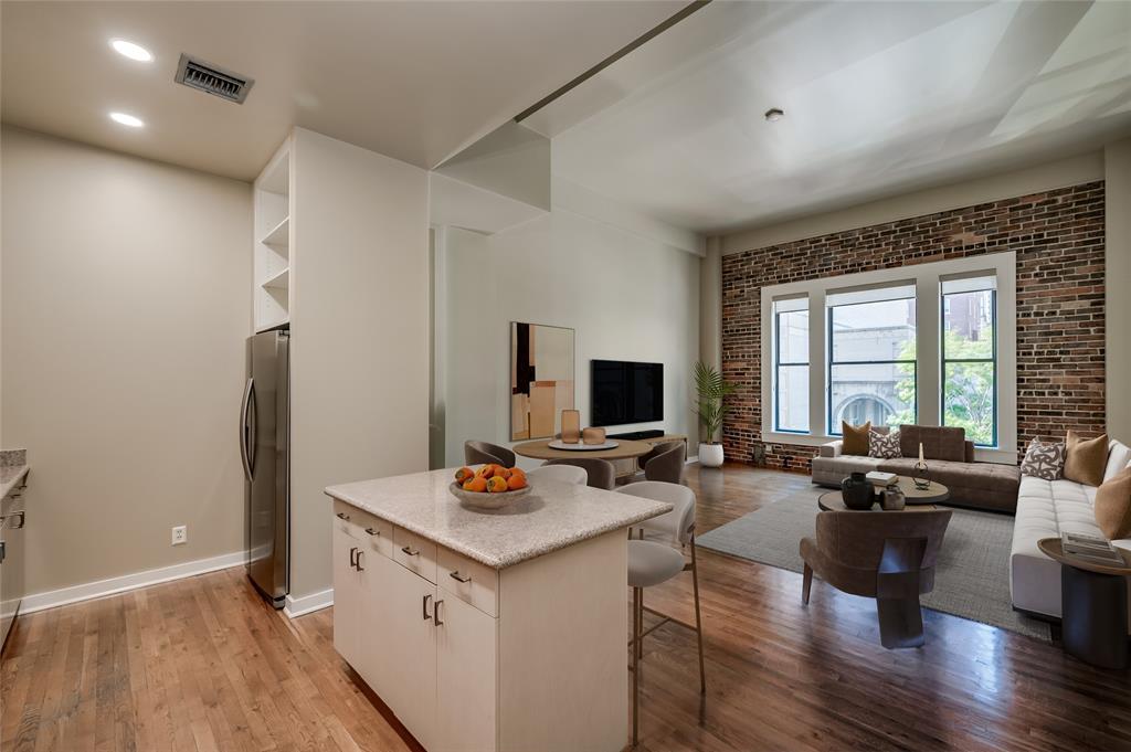 Pristine 2nd floor unit at  Bayou Lofts in Downtown's Historic District! Desirable floor plan showcases large Living/Dining Room open to spacious Kitchen!  13' ceilings throughout most of unit! Fresh paint throughout unit (Sept 2024).  PHOTO VIRTUALLY STAGED.