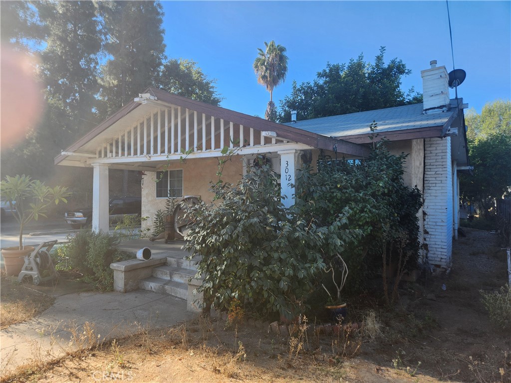 a front view of a house with plants and trees