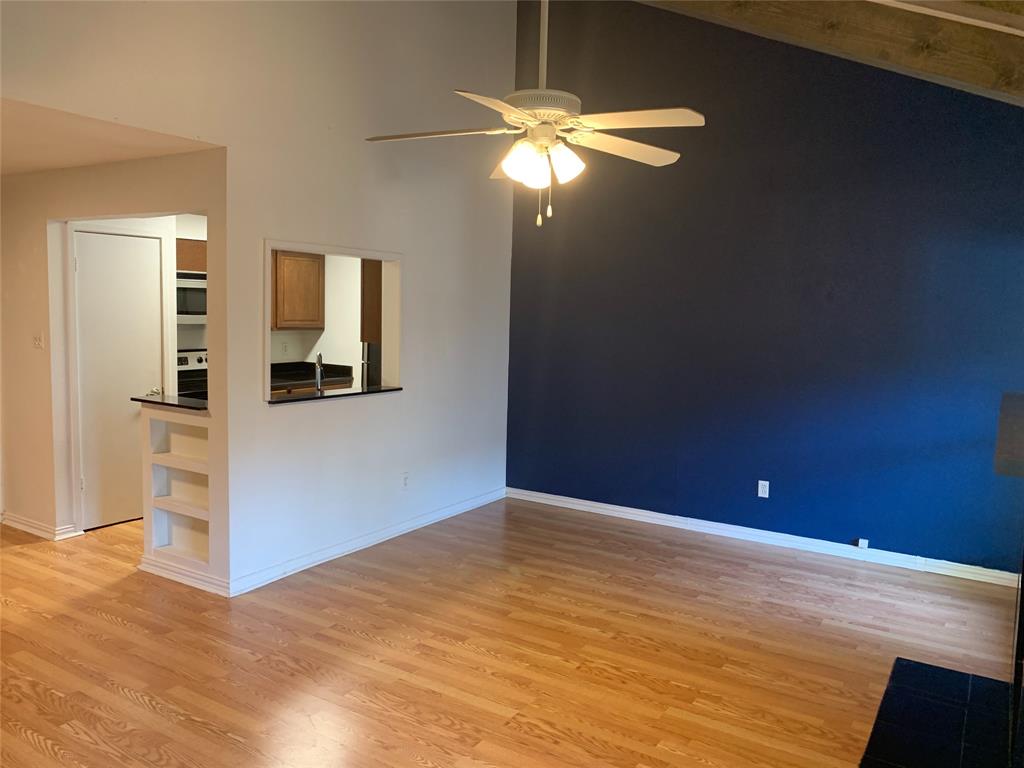 a view of empty room with window and wooden floor