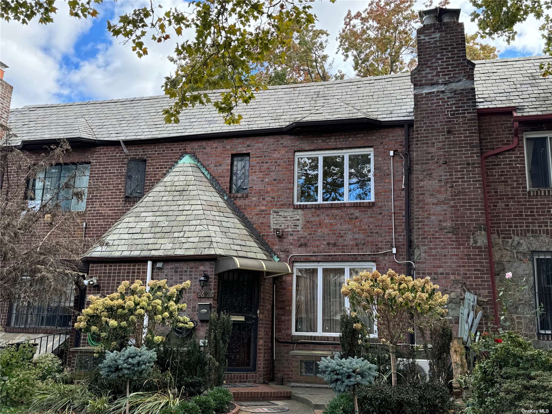 a front view of a house with a garden