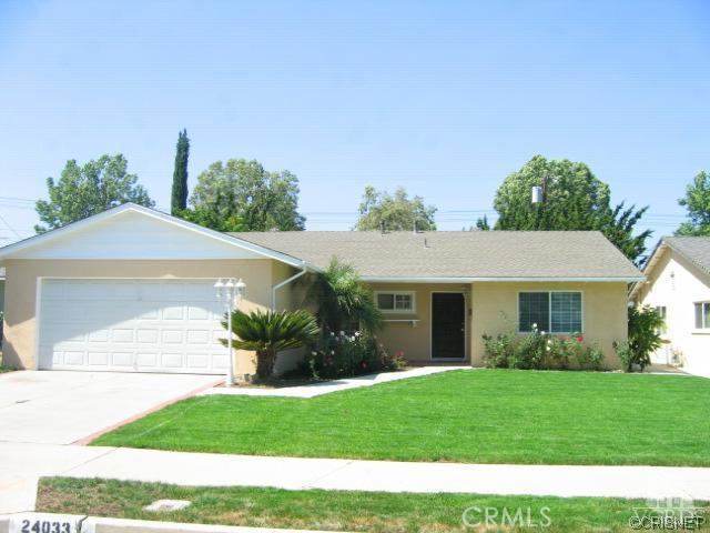 a front view of a house with a yard and potted plants