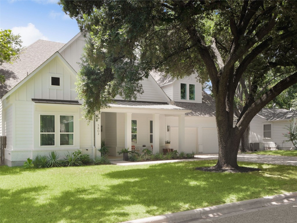 a front view of a house with a garden and trees