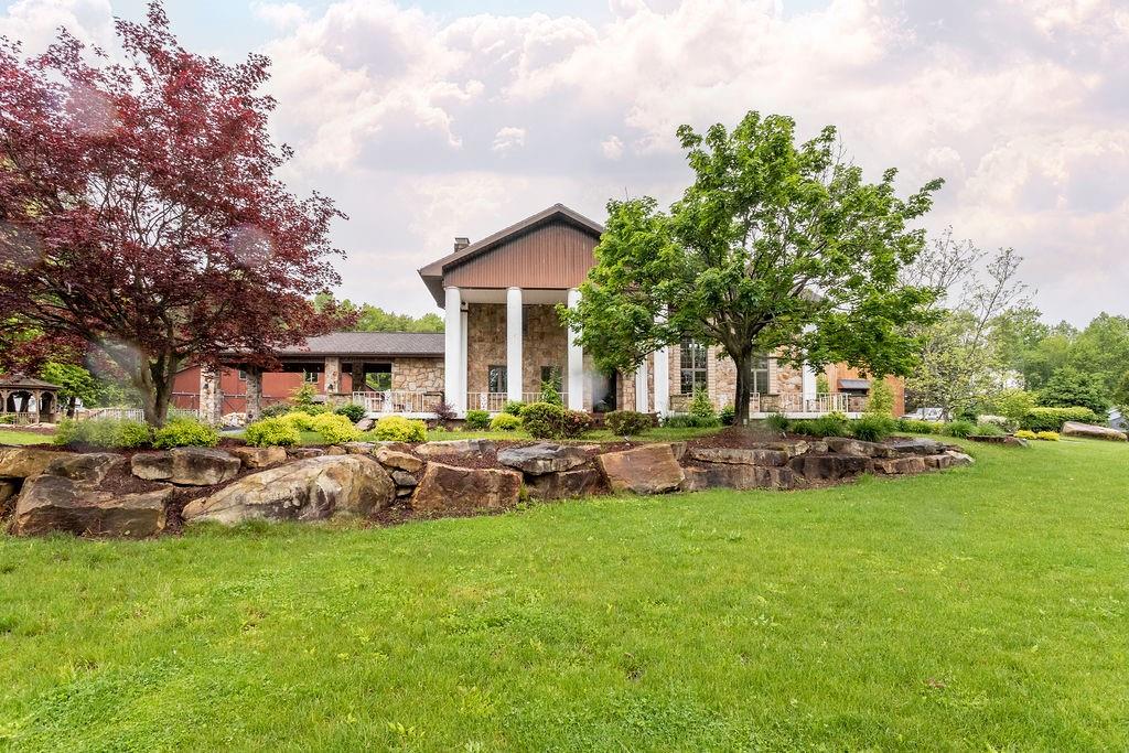 a view of a house with backyard sitting area and garden