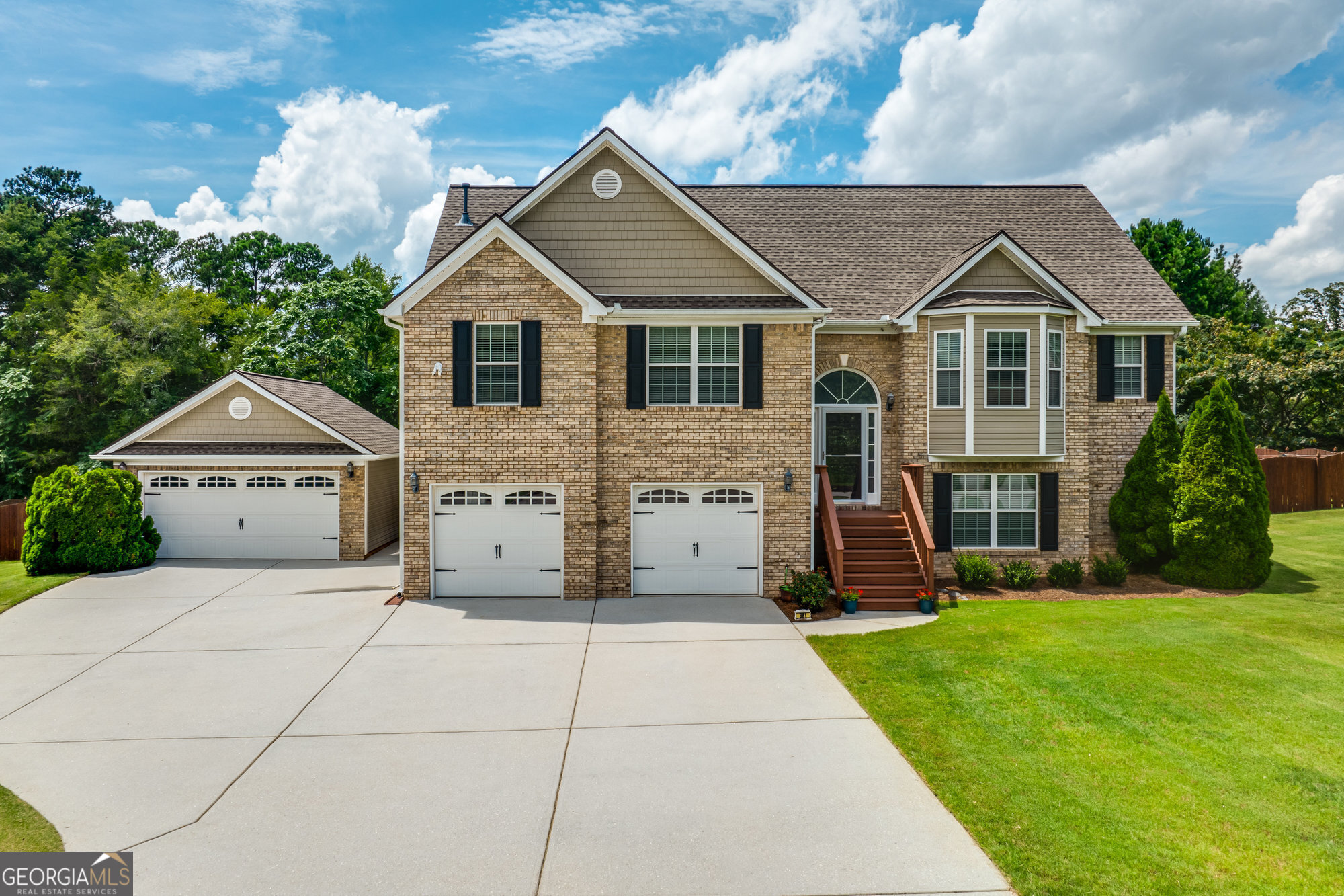 a front view of a house with a yard and trees