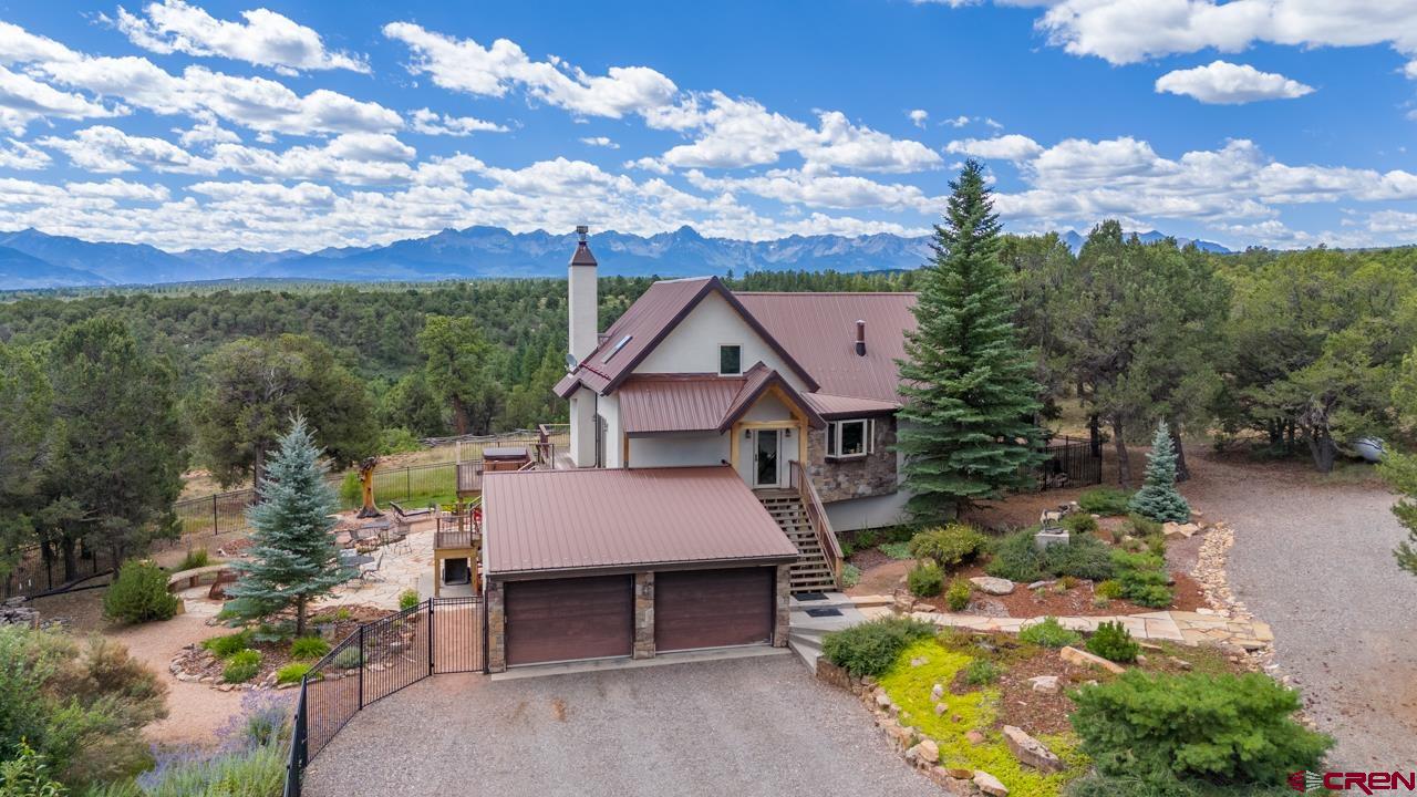 a aerial view of a house with a yard and balcony