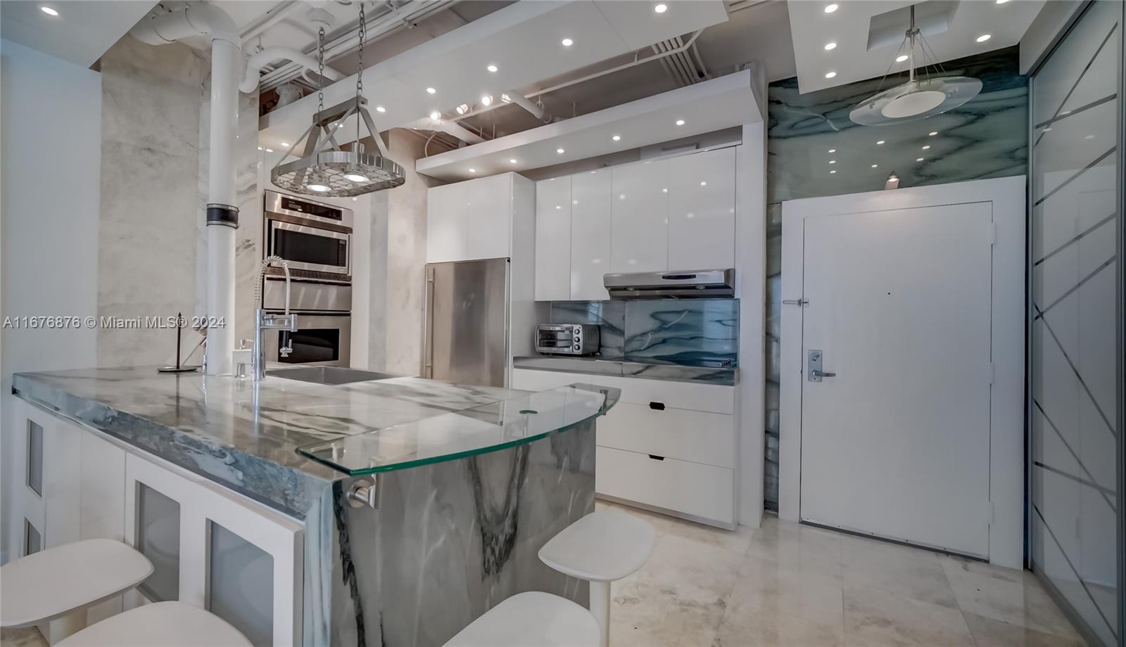 a kitchen with stainless steel appliances granite countertop a sink and a refrigerator