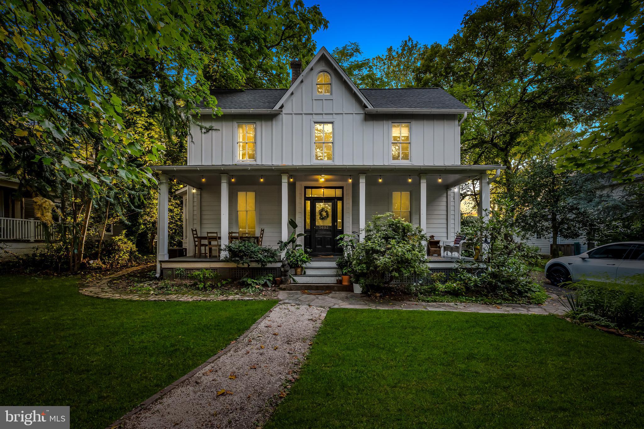 a front view of a house with a yard and trees