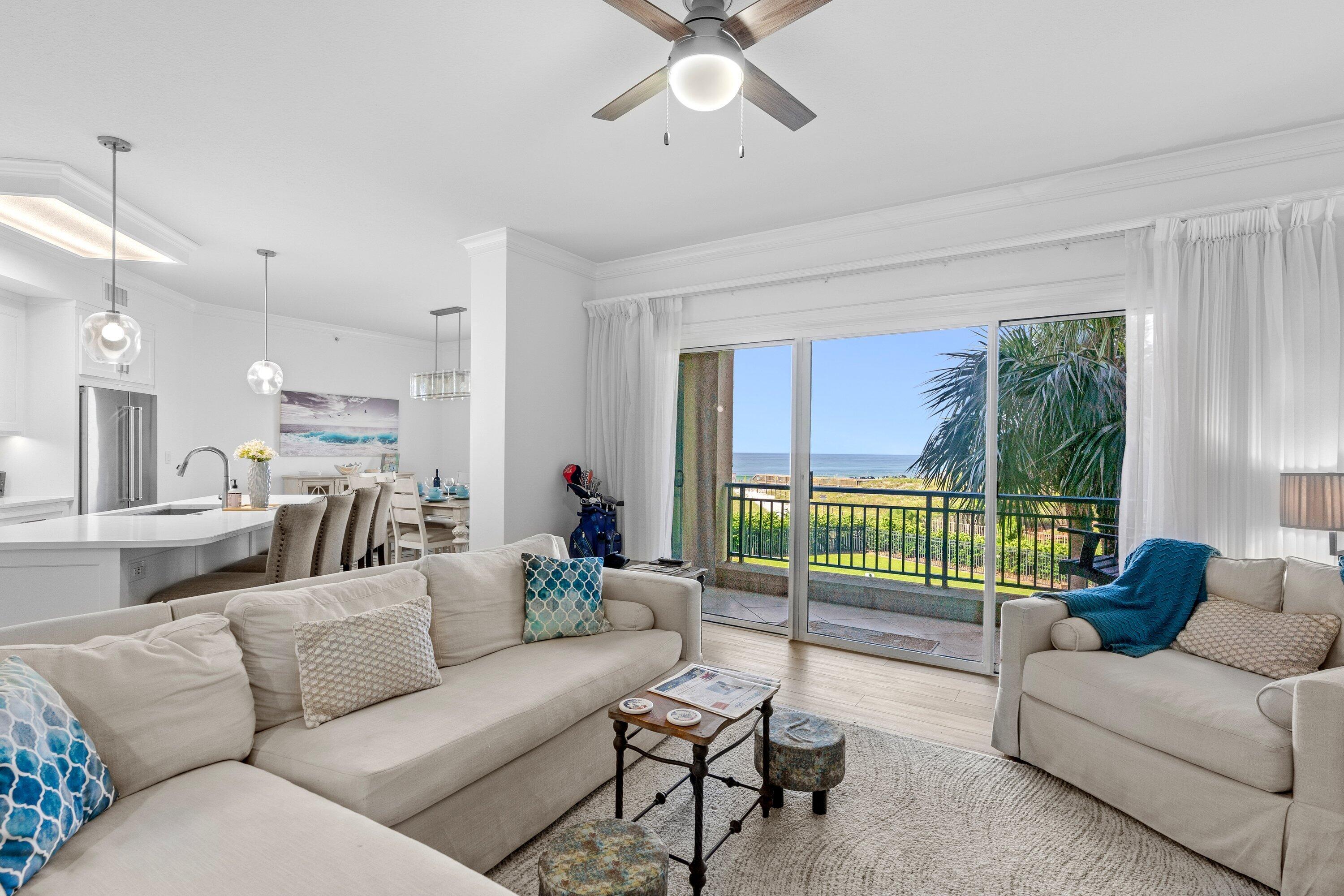 a living room with furniture and a large window with balcony view