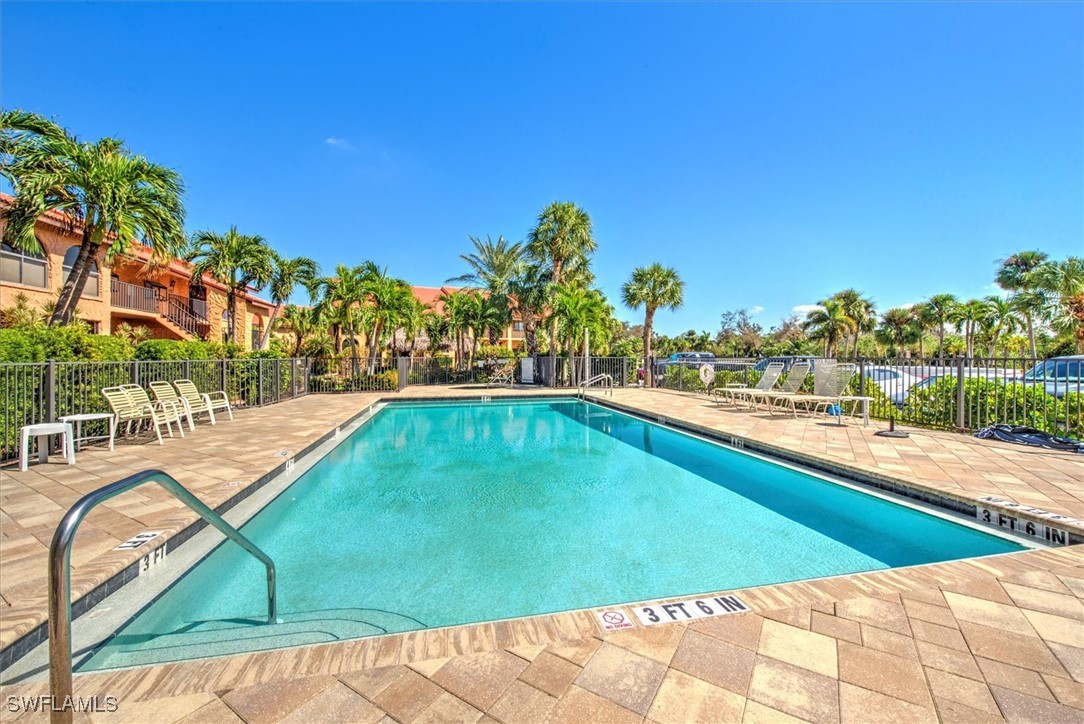 a view of a swimming pool with a lawn chairs and a fire pit