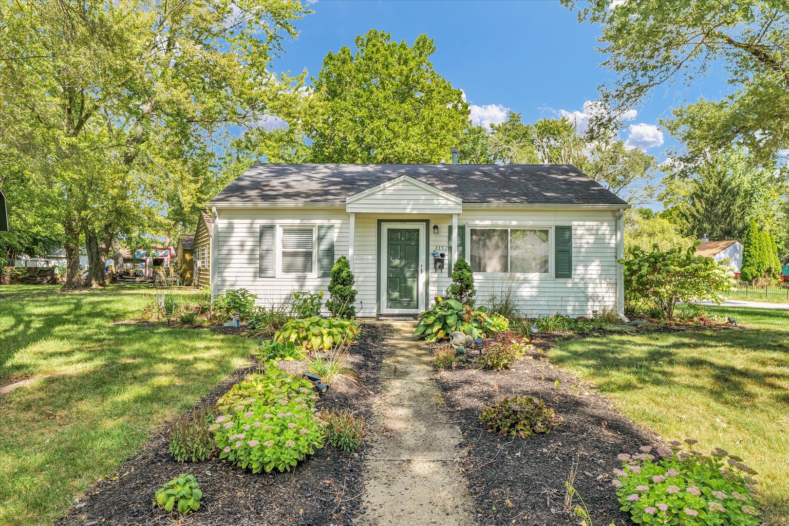 a front view of a house with a garden