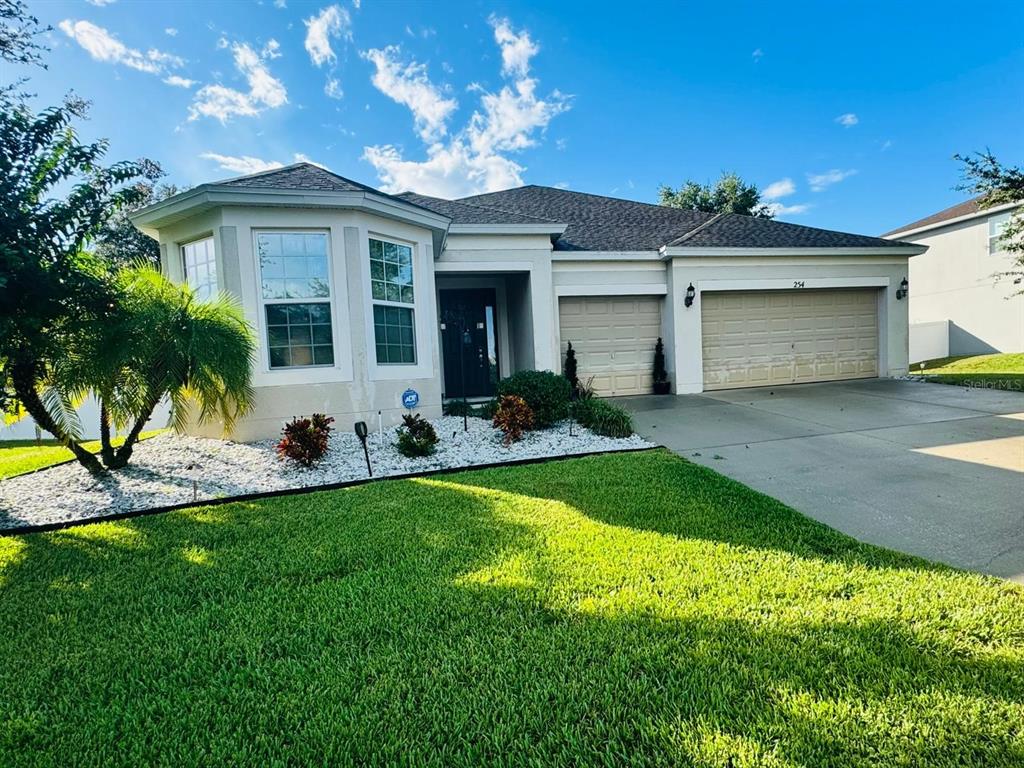 a front view of a house with a garden and yard