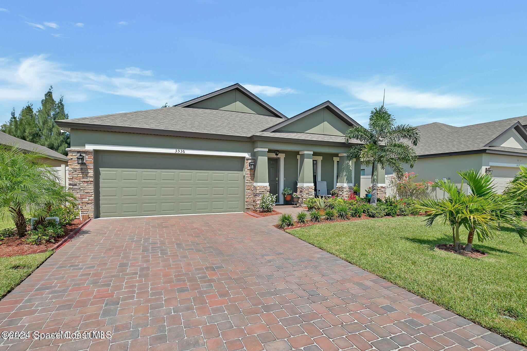 a front view of a house with yard and green space