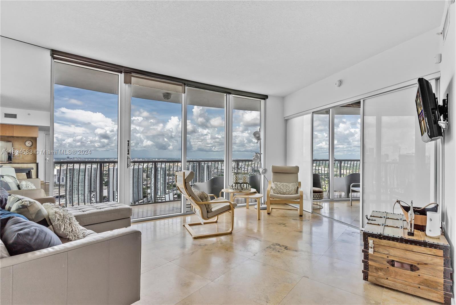 a living room with furniture and a large window with balcony view