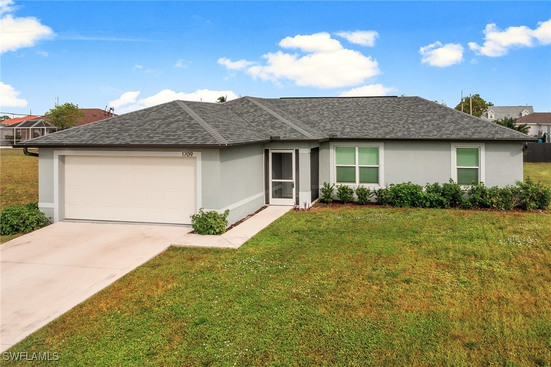 a front view of a house with yard and garage