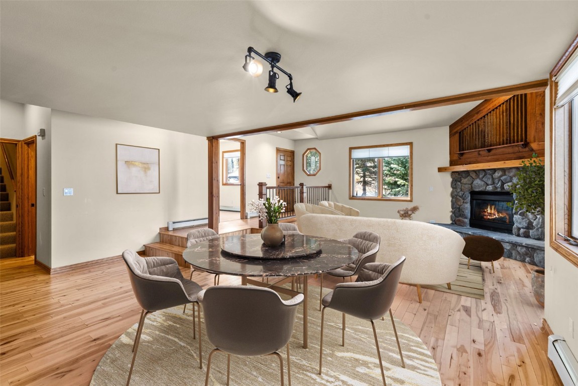 a dining room with furniture a chandelier and wooden floor