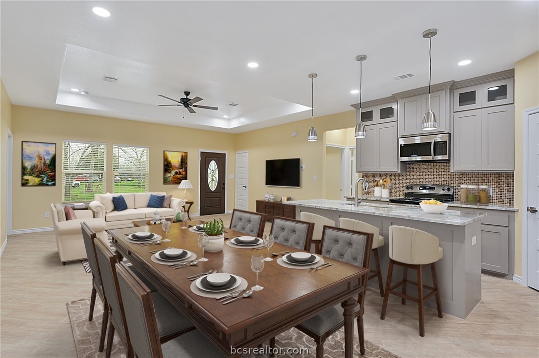 a large dining room with stainless steel appliances granite countertop a table and chairs