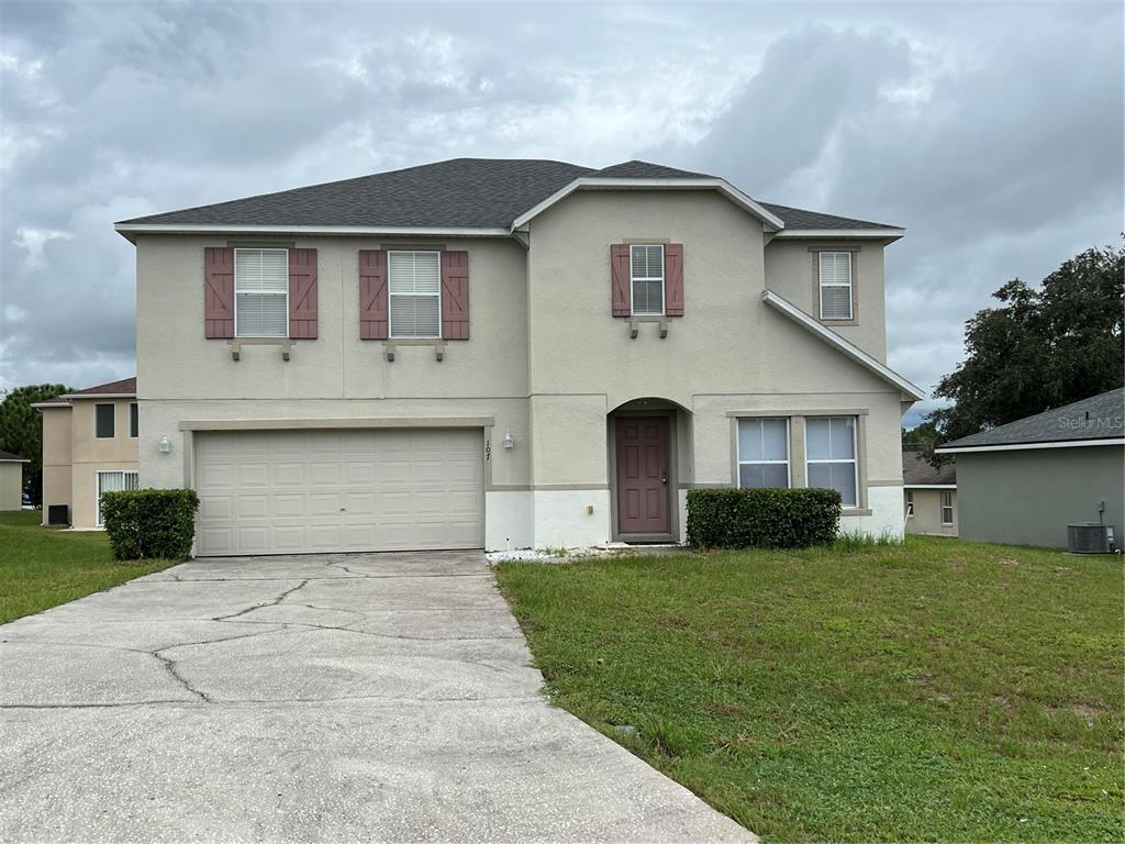 a front view of house with yard and garage