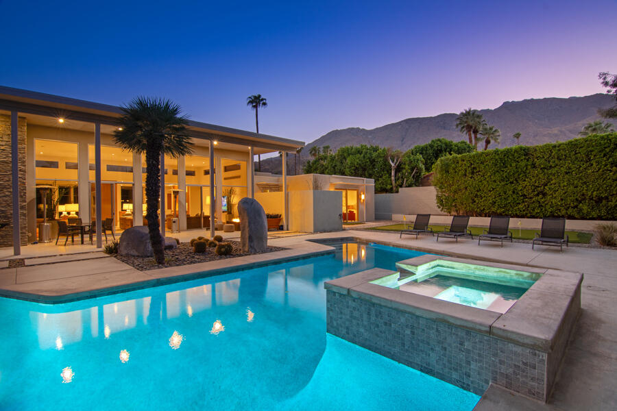 a view of a swimming pool with a couches and table in the patio