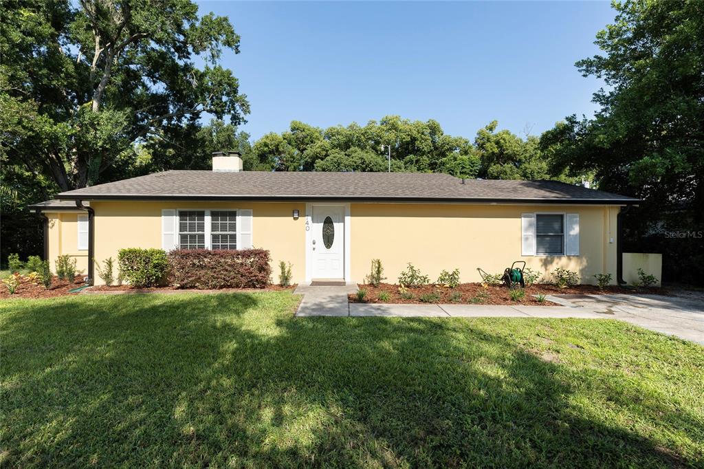 a view of a house with backyard and sitting area