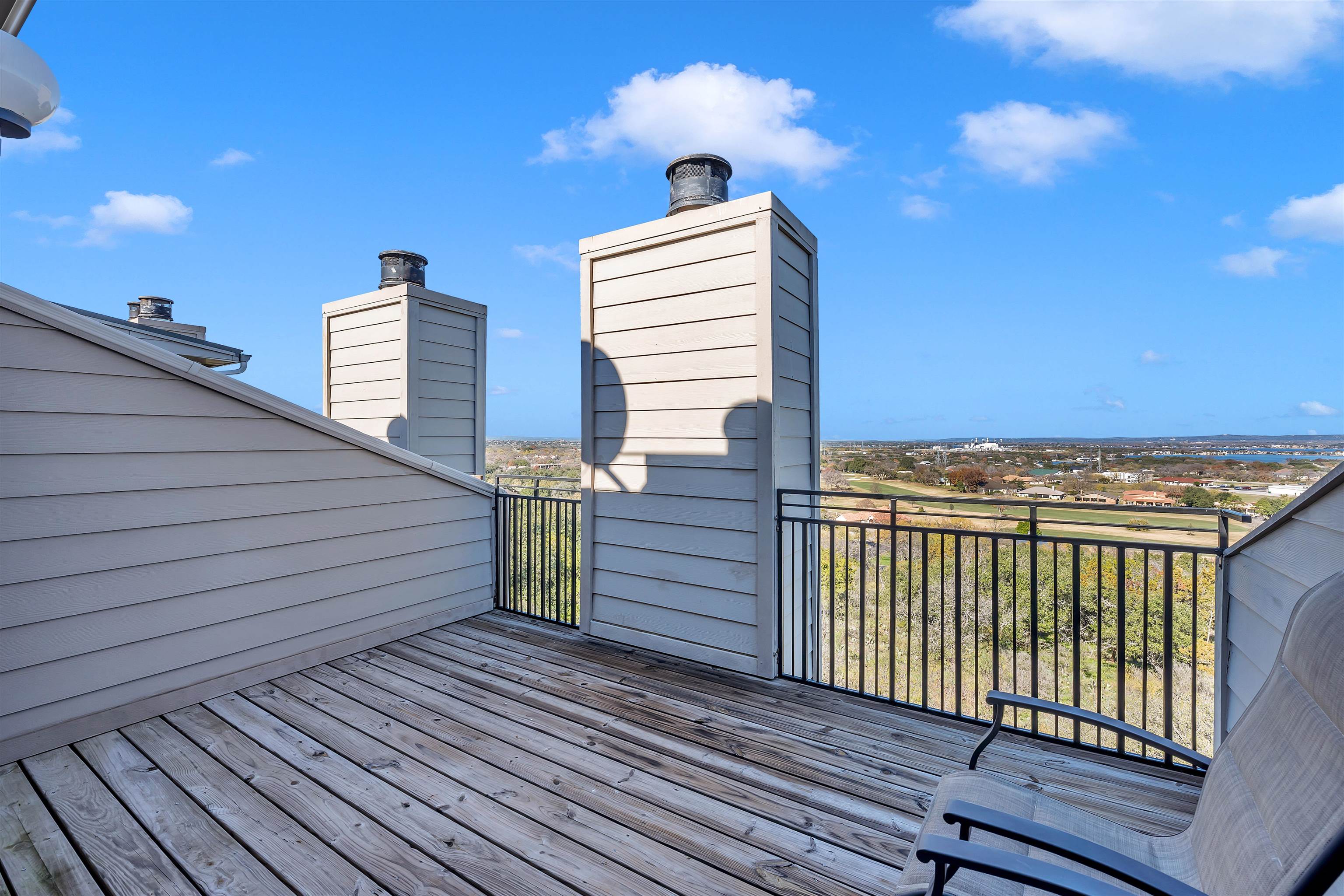 a view of a roof deck with wooden floor and fence