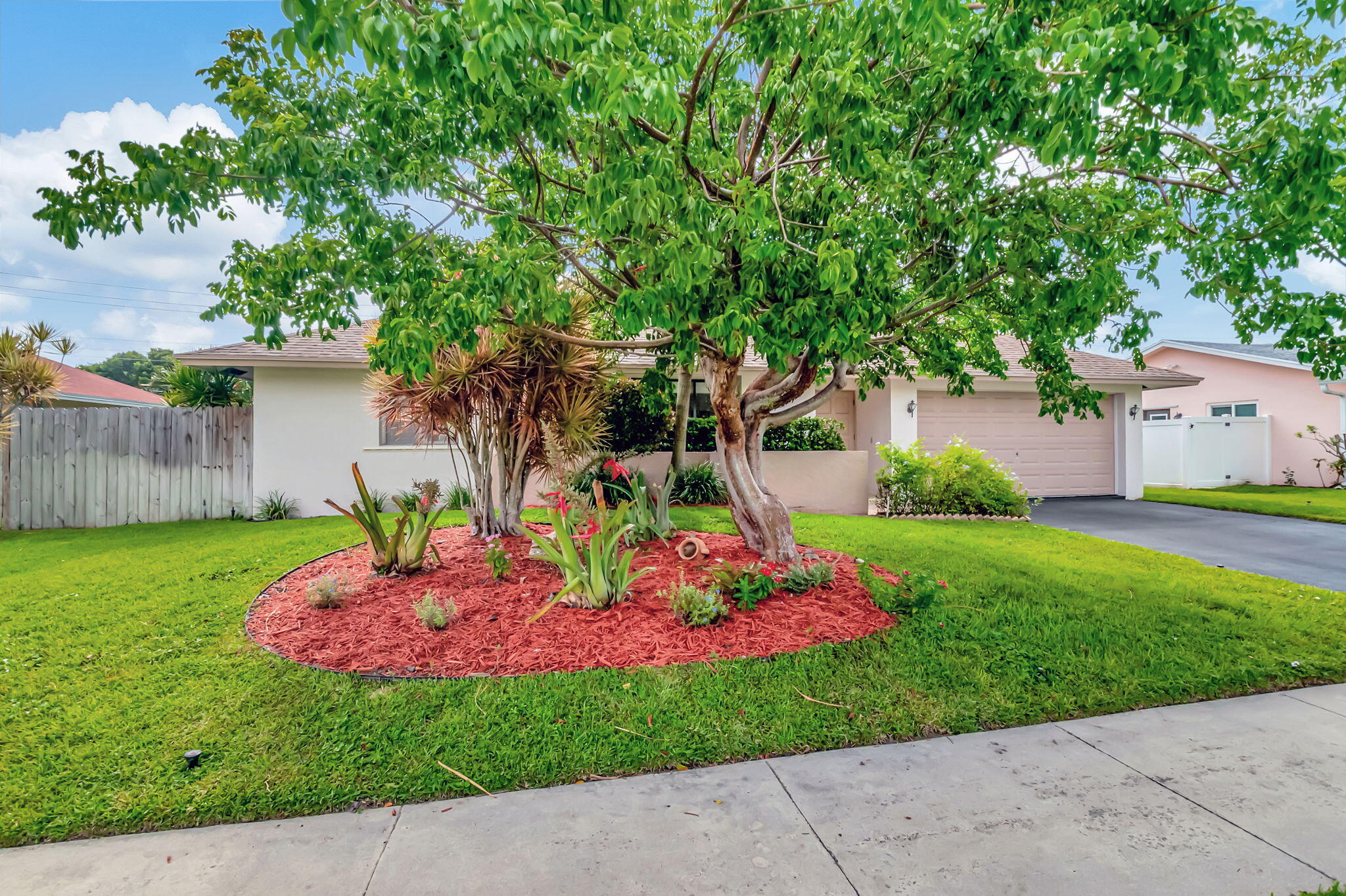 a front view of a house with a big yard and potted plants