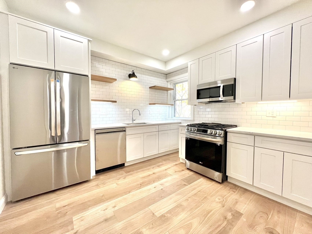 a kitchen with stainless steel appliances a refrigerator sink and microwave