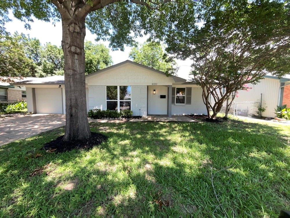 a front view of house with yard and trees