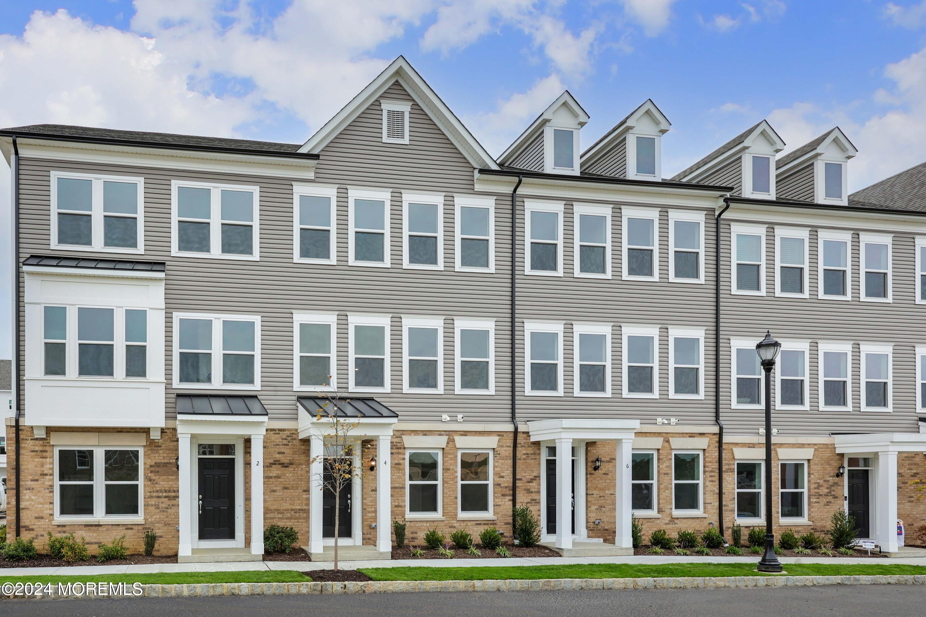 a front view of a residential apartment building with a yard