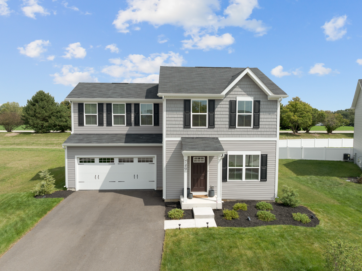 a front view of a house with a yard and garage