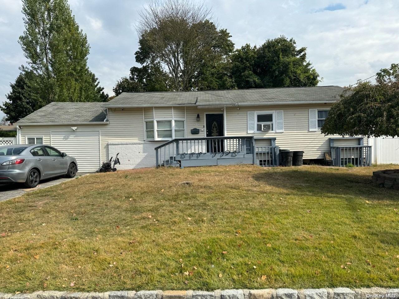 a front view of a house with a yard and car parked