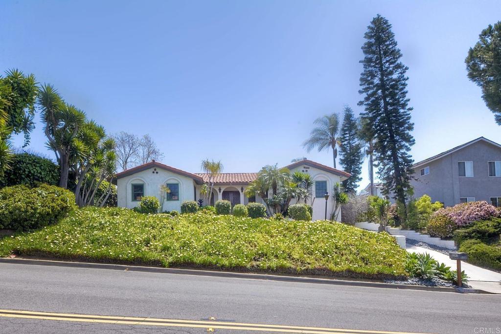 a front view of a house with a yard and potted plants