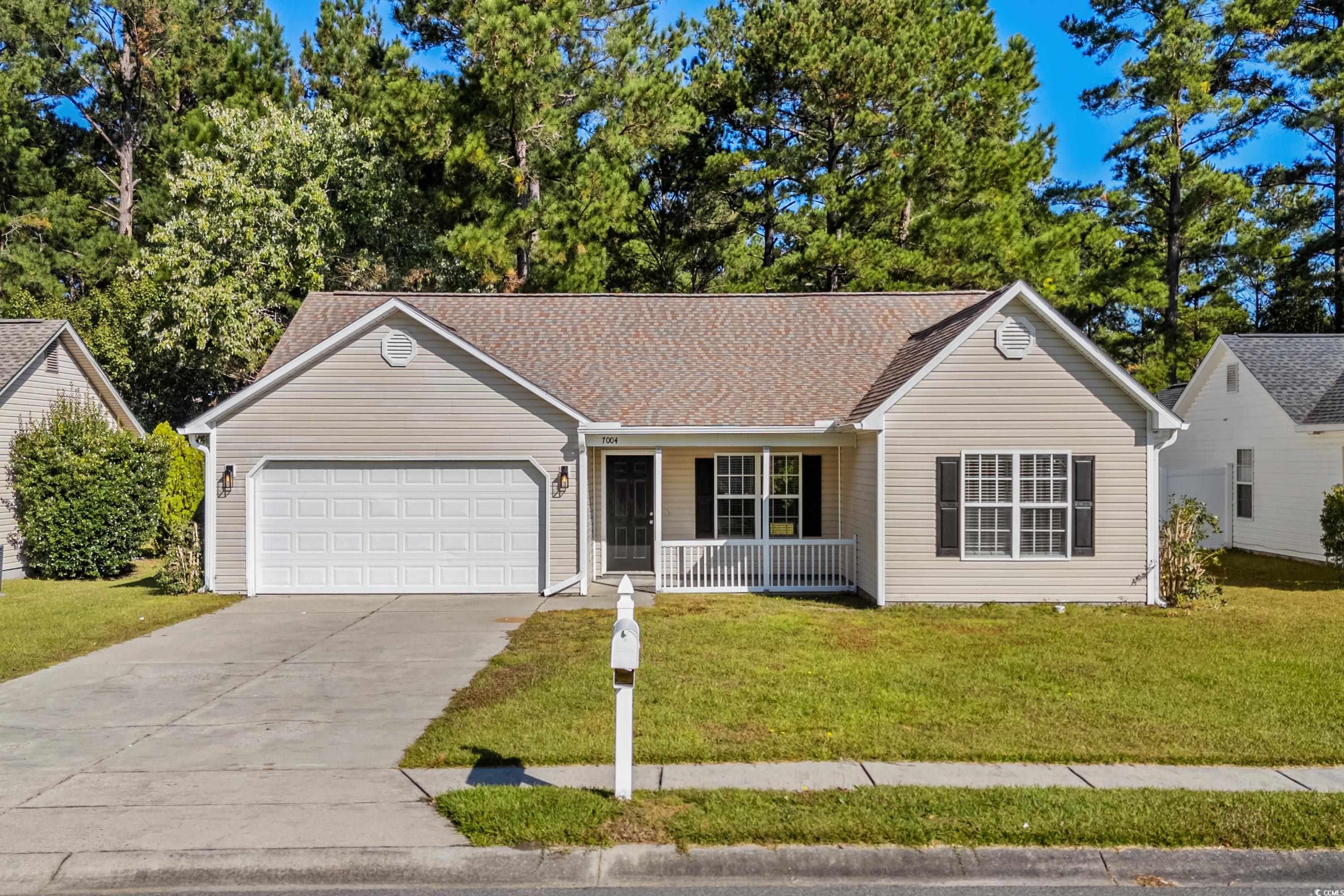 Ranch-style house with a garage, a front lawn, and