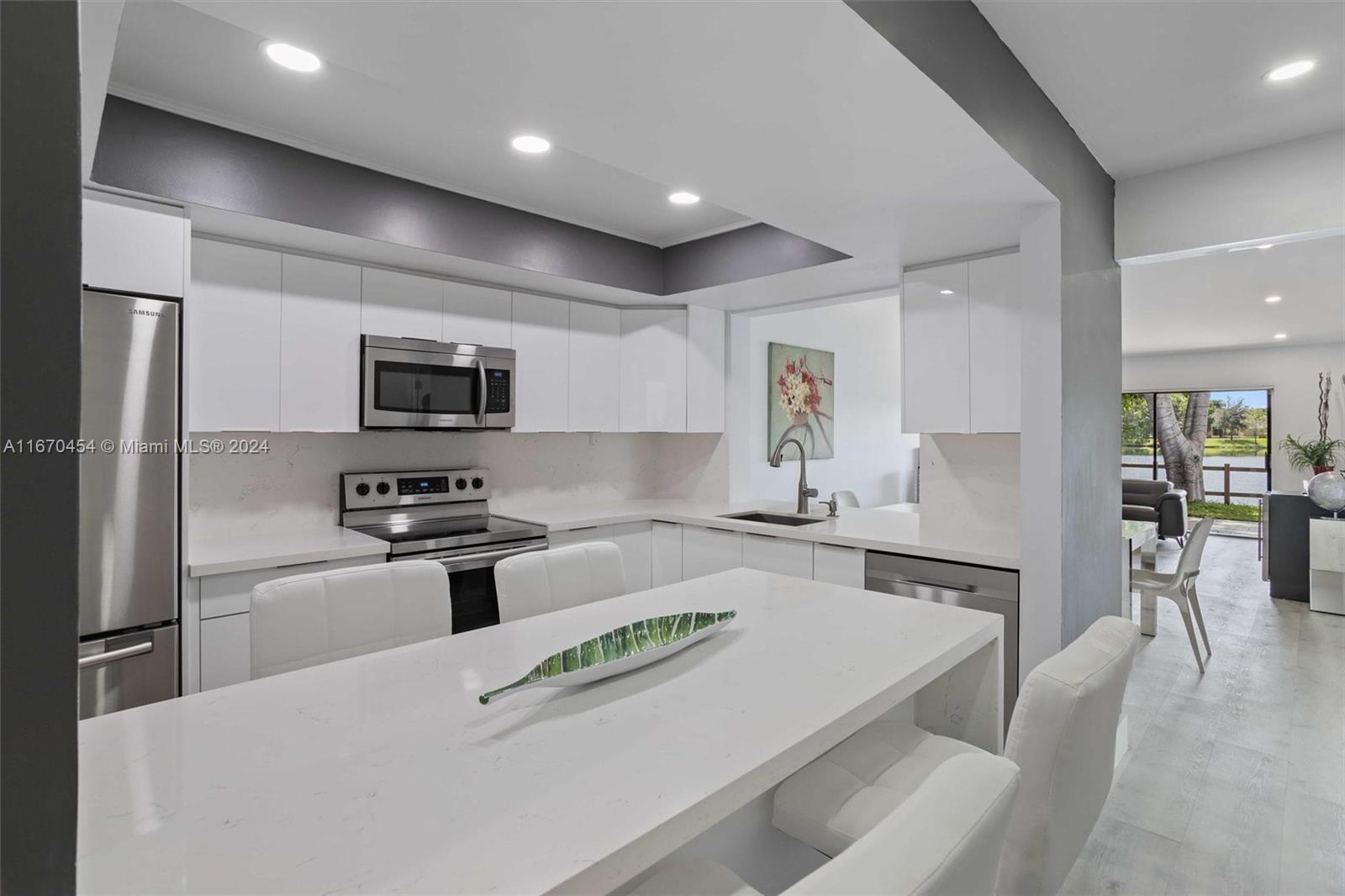 a kitchen with stainless steel appliances a stove a sink a refrigerator a center island and chairs