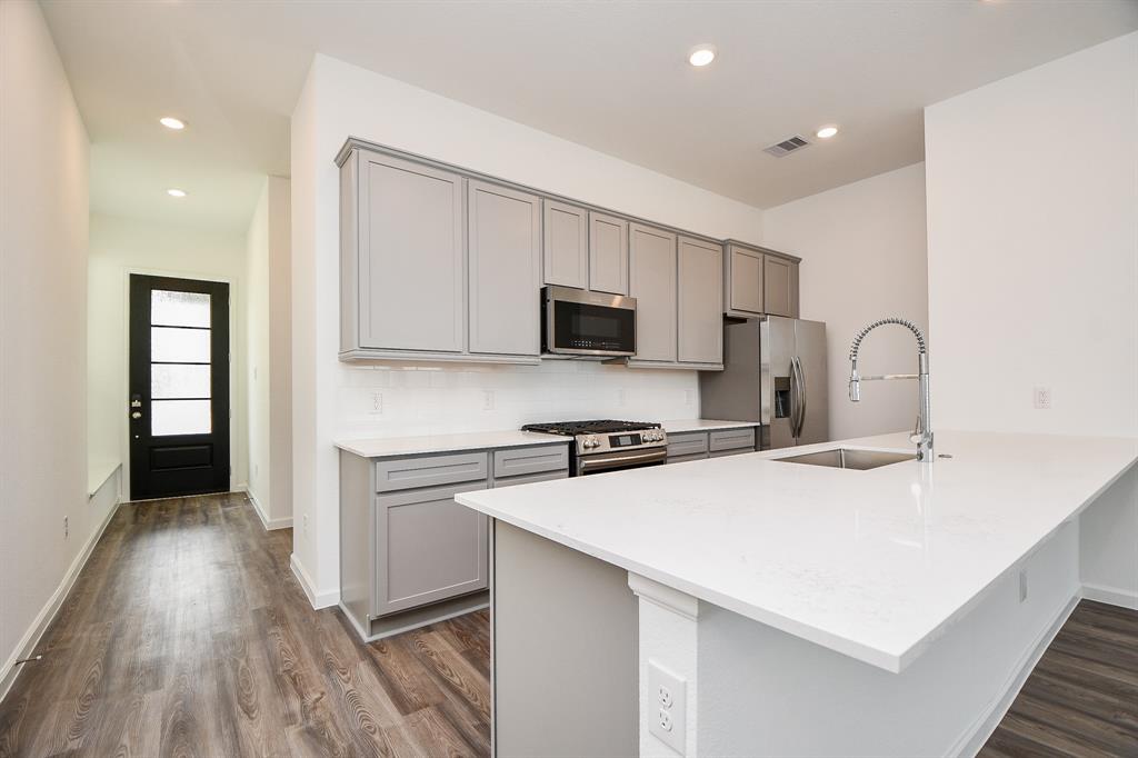 a kitchen with a sink a stove a refrigerator and cabinets