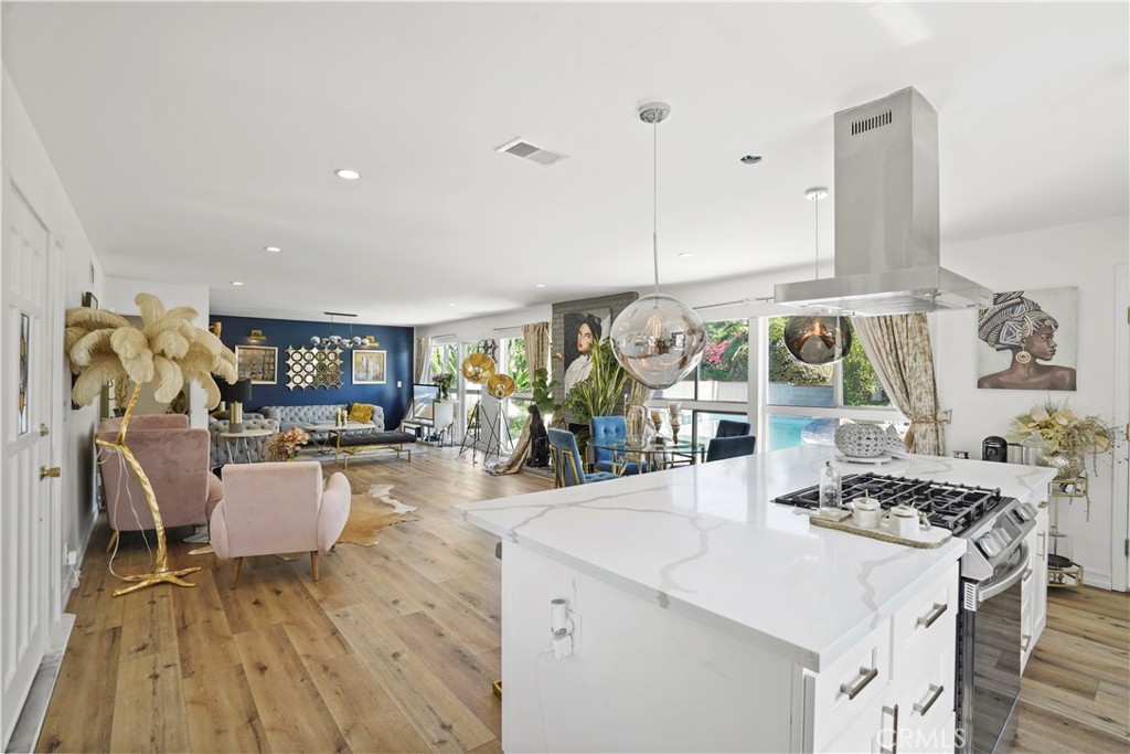 a kitchen with stainless steel appliances granite countertop a stove and a wooden floors