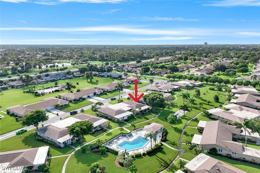 an aerial view of residential houses with outdoor space and swimming pool