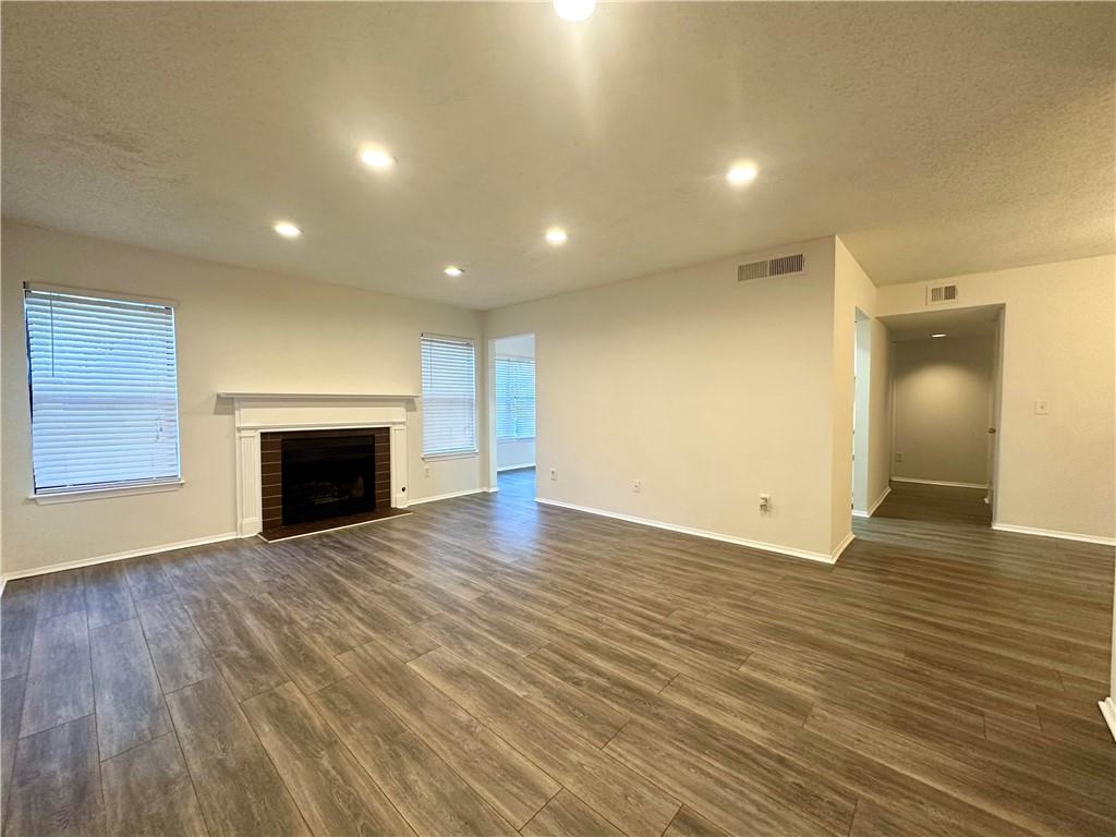 an empty room with wooden floor and fireplace