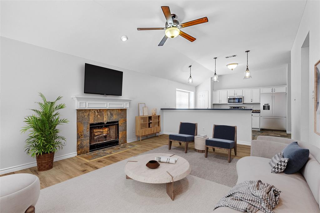 a living room with furniture a fireplace and a flat screen tv