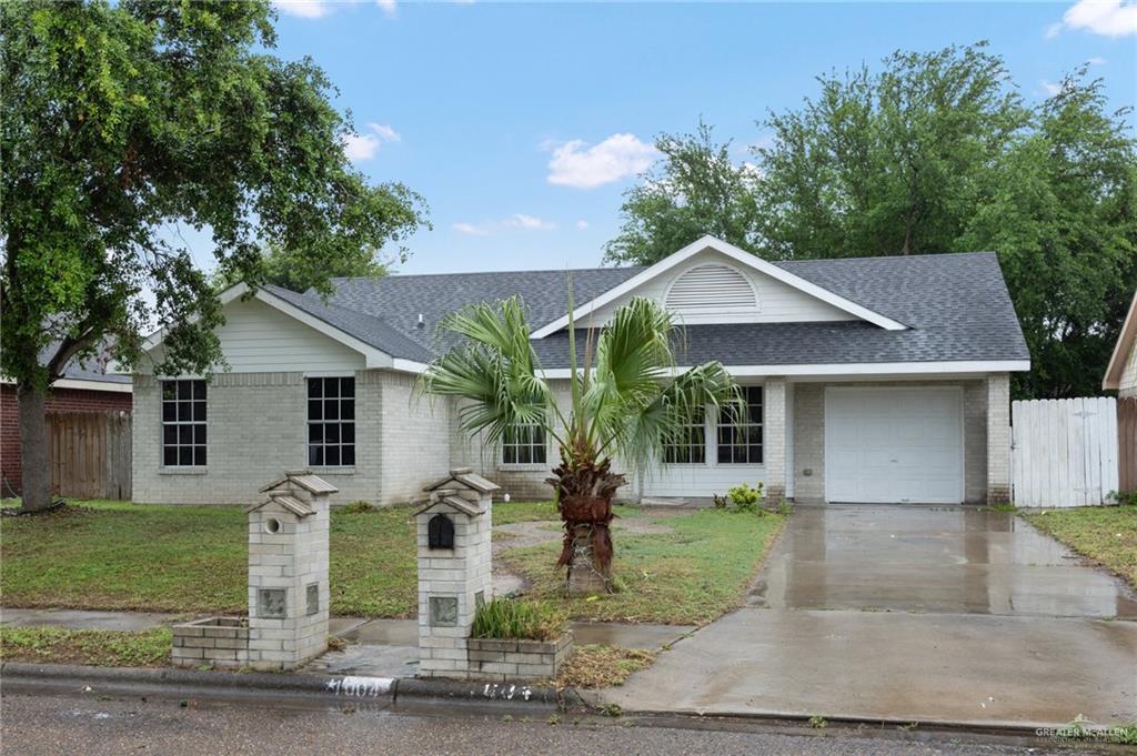 Ranch-style home featuring a garage and a front lawn