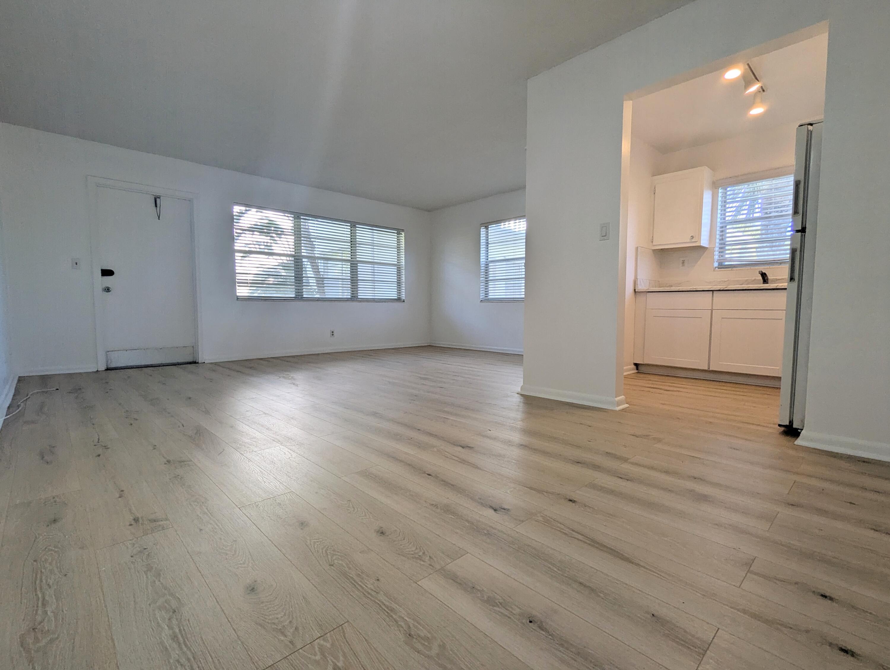 a view of a kitchen with wooden floor and windows