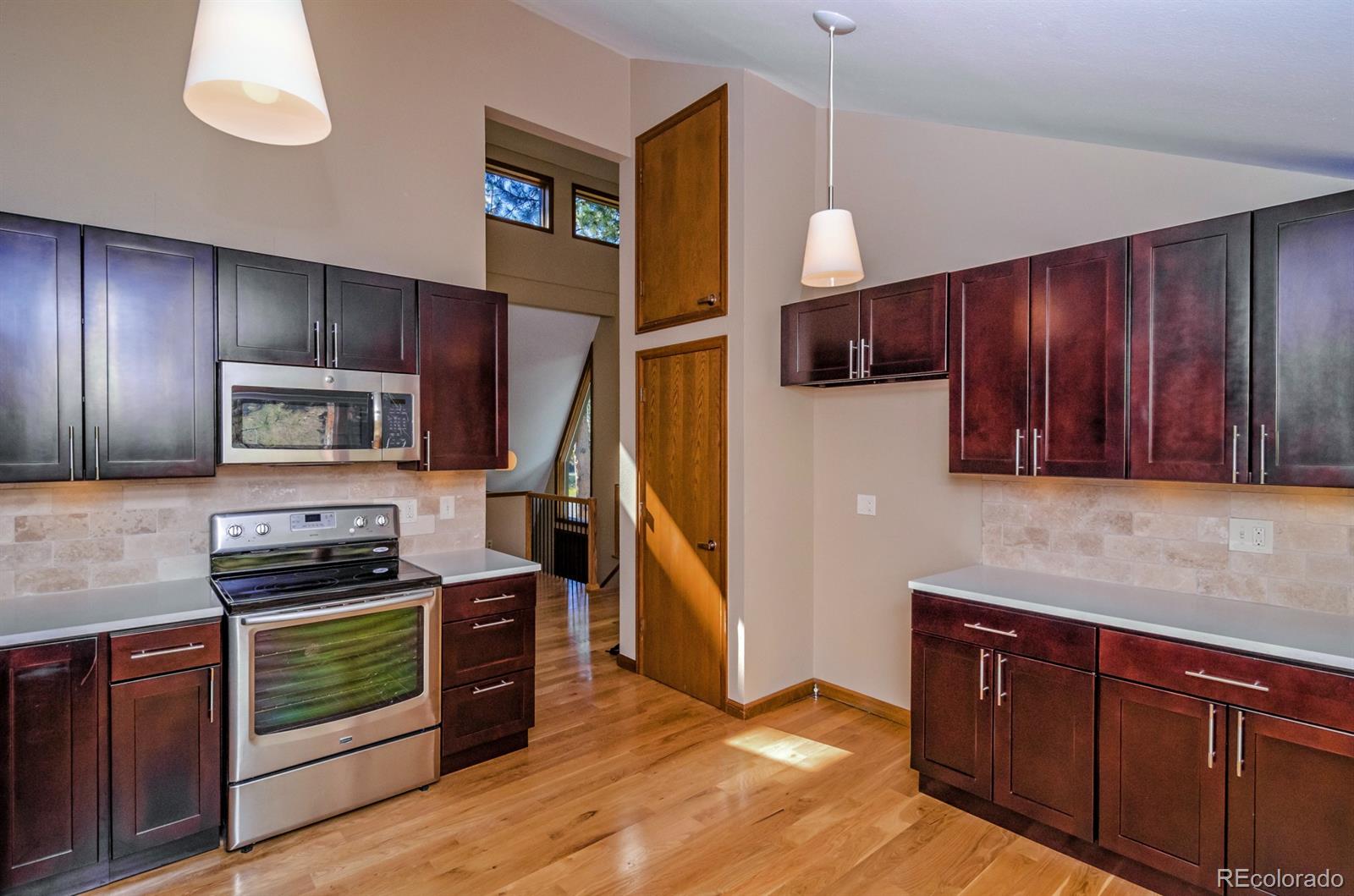 a kitchen with stainless steel appliances granite countertop a refrigerator and a stove top oven