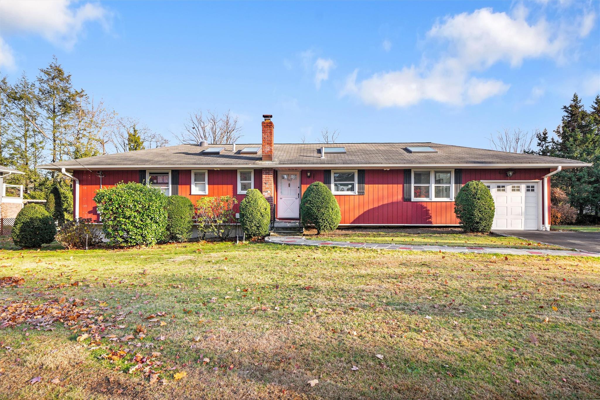 Ranch-style home featuring a garage and a front lawn