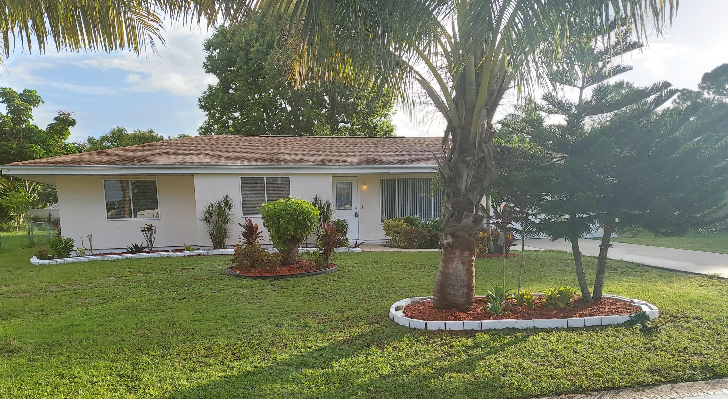 a front view of house with a garden