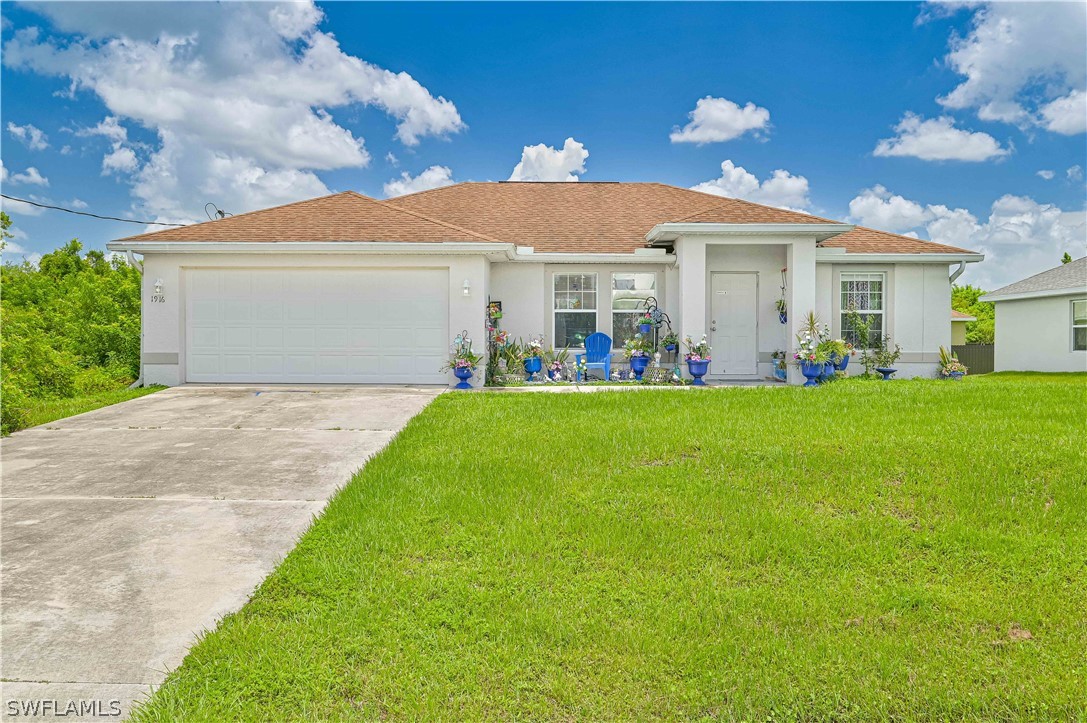 a front view of a house with a garden and yard